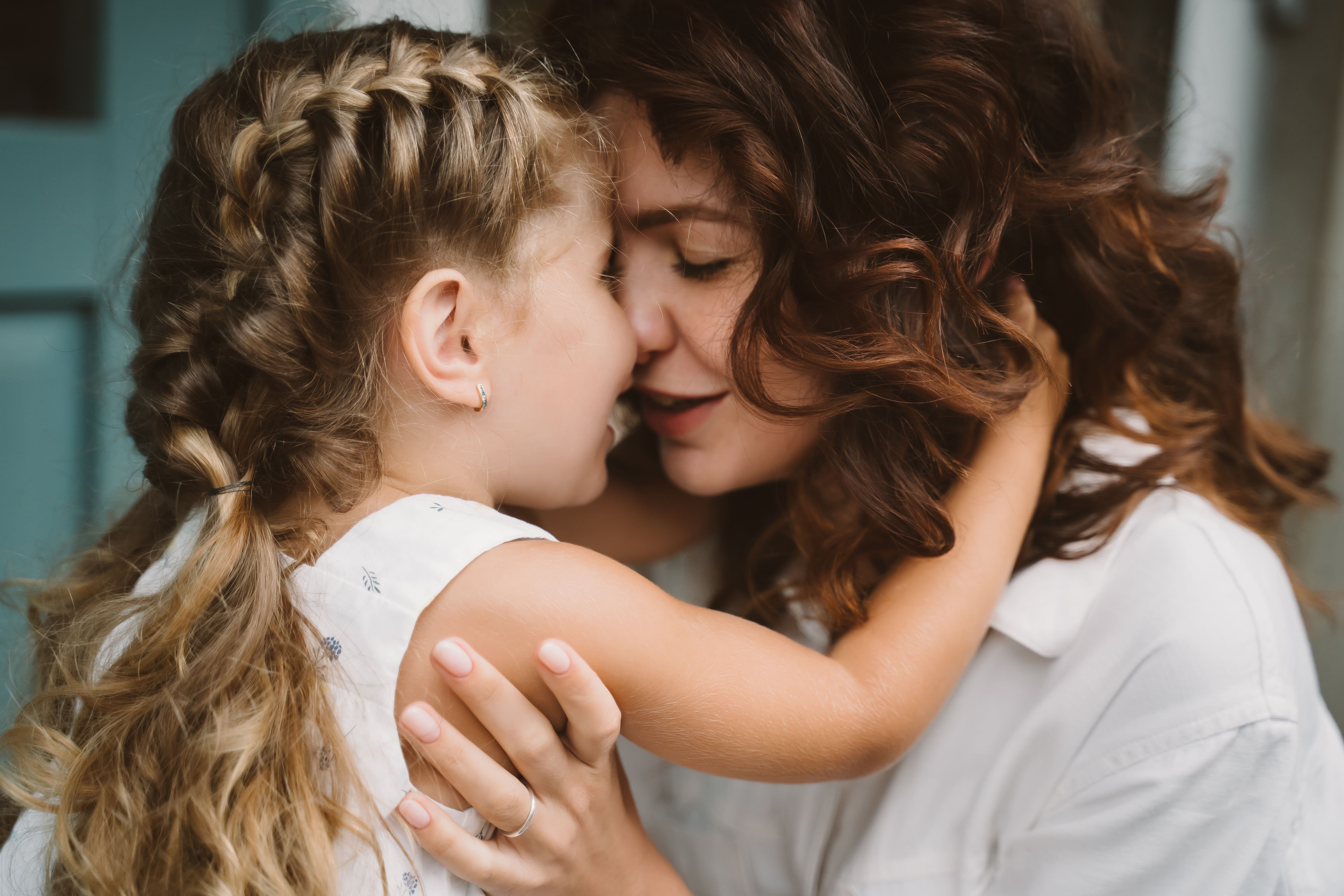 portrait-little-daughter-kissing-her-beautiful-happy-mother (1).jpg